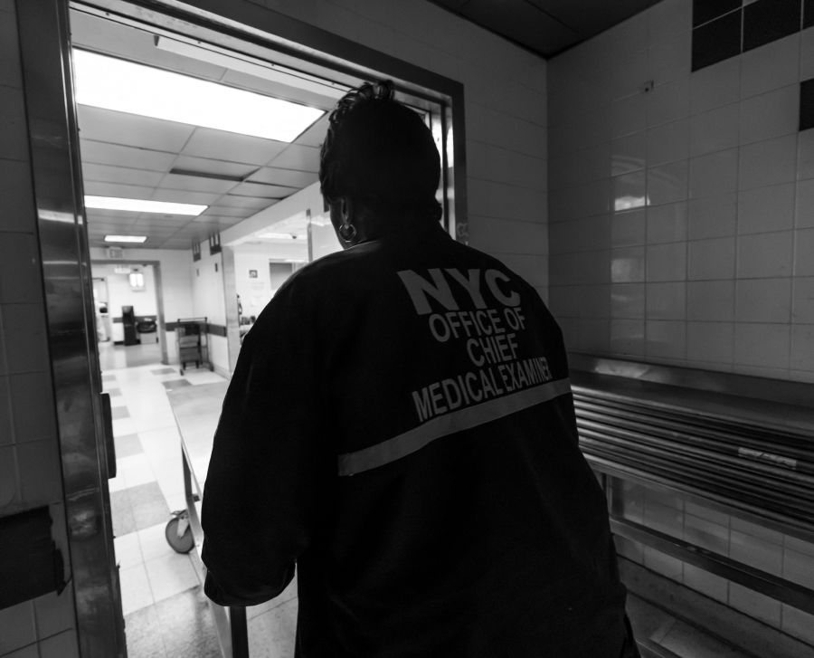 An Office of Chief Medical Examiner employee wheels a table down the morgue hallway.