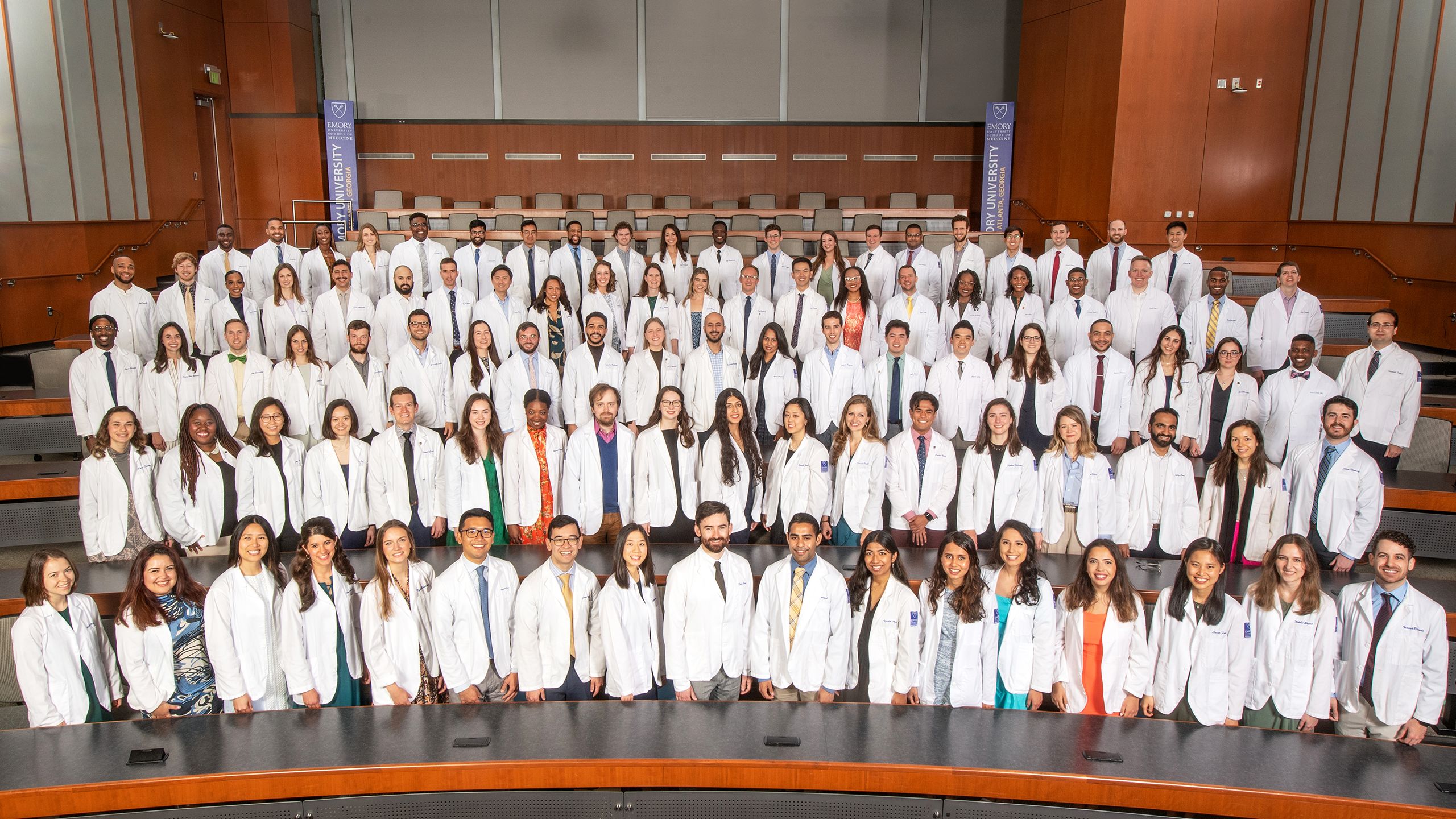 MD Class of 2023 in white coats pose for a formal class photo