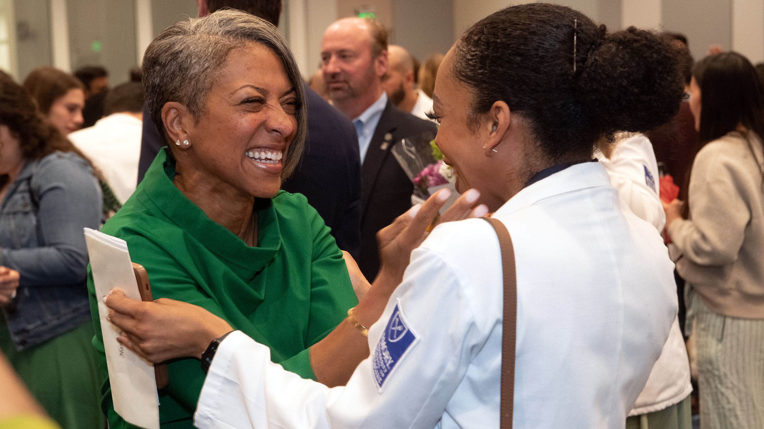 A professor hugs a med student in celebration