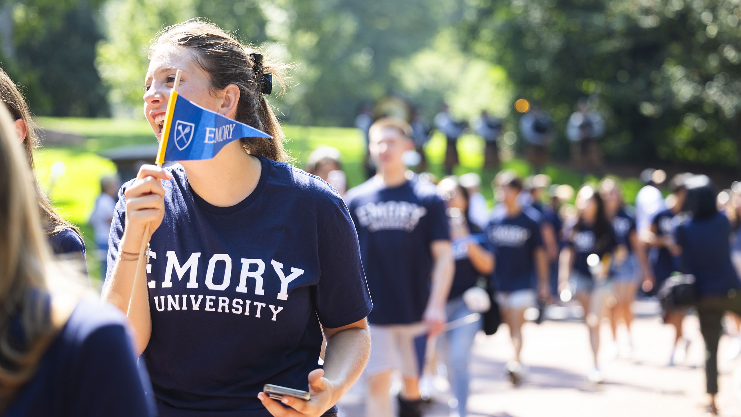 Students in Emory t-shirts wave pennants