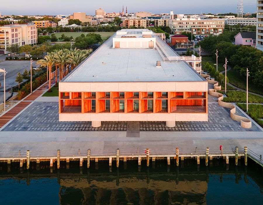 Shot of International African American Museum with wharf in foreground and city of Charleston in background