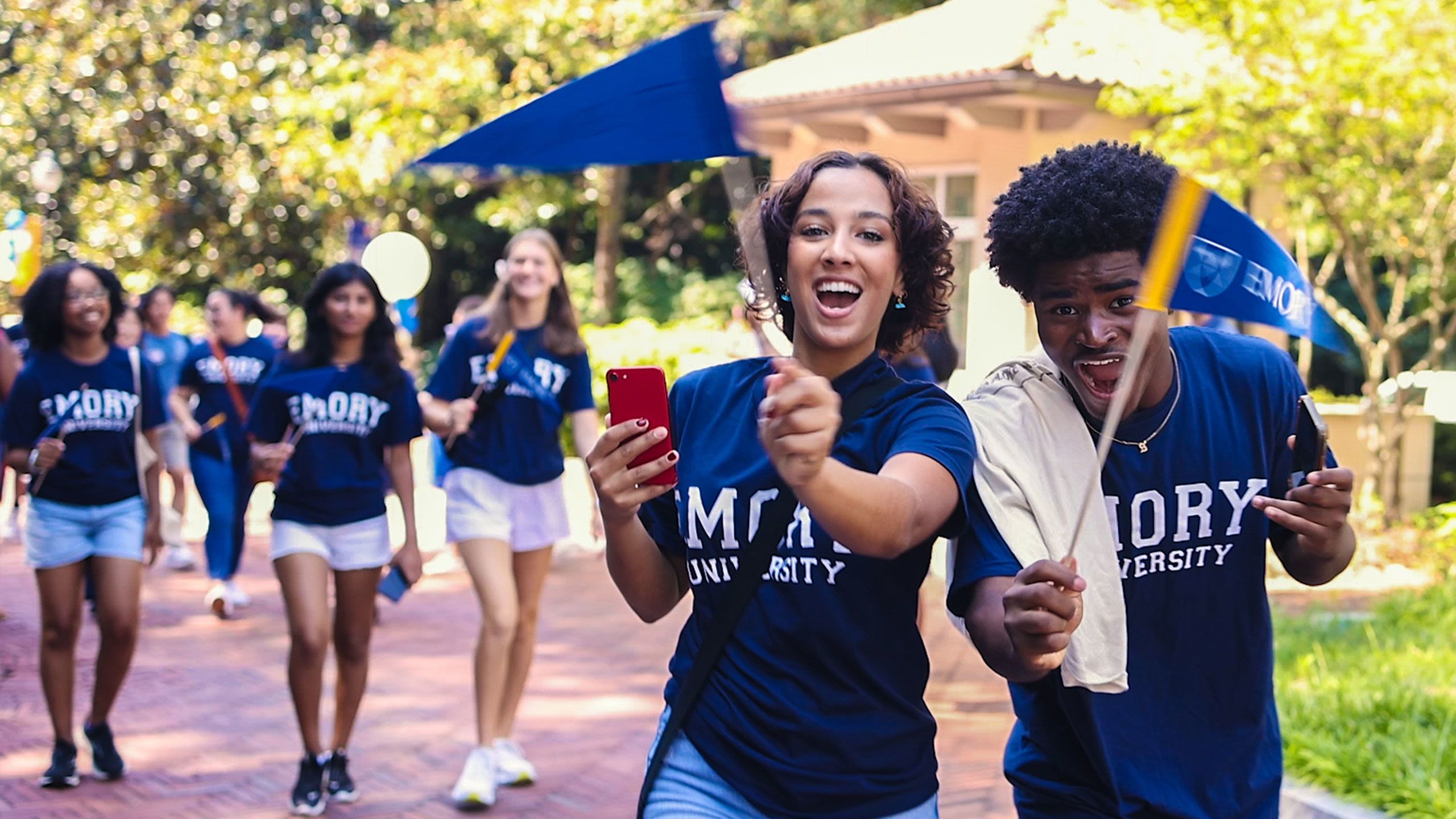 Students in Emory t-shirts wave pennants