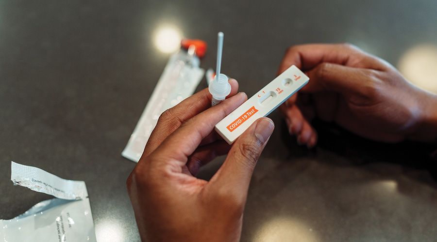 Hands holding a covid test in process of being used.