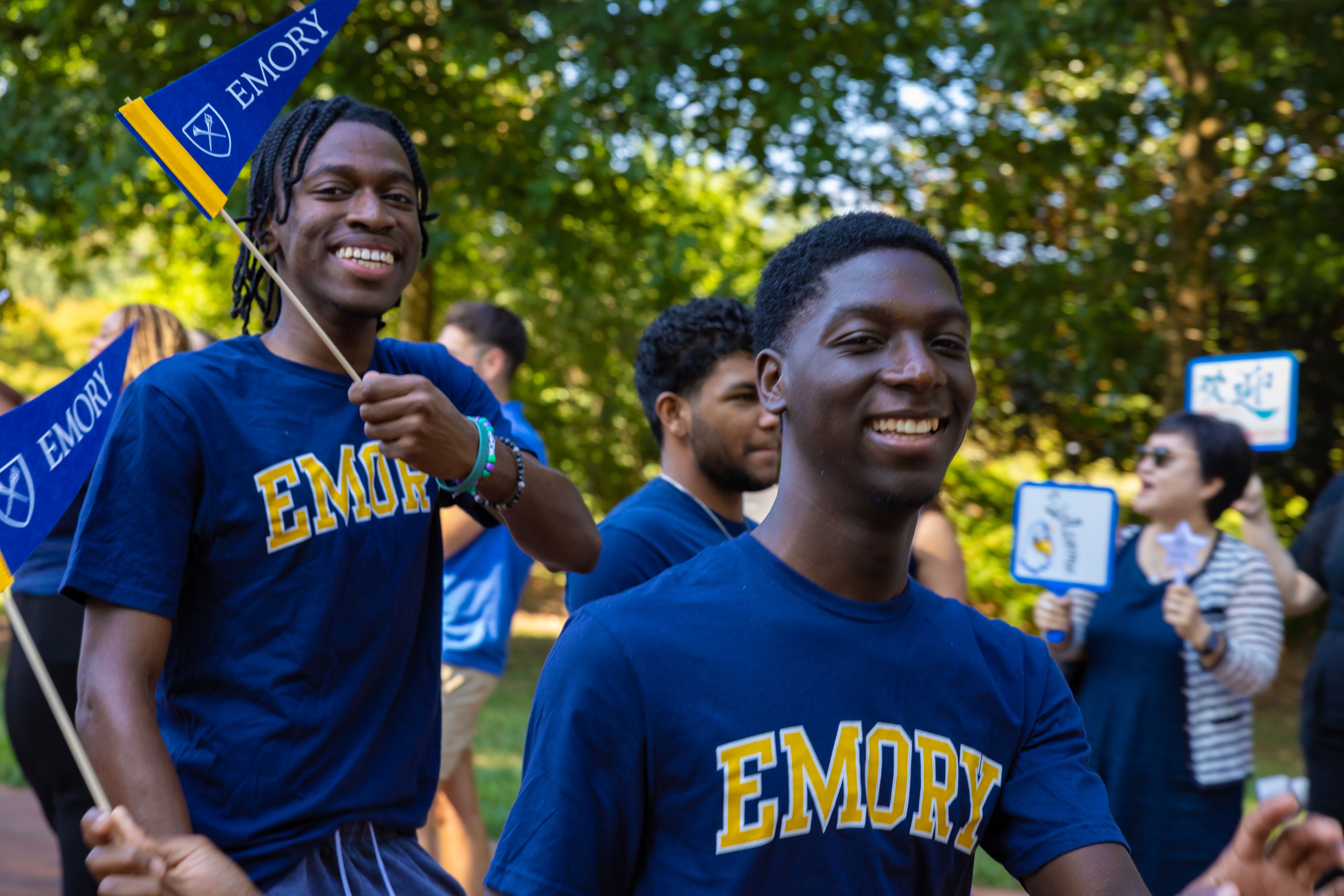 Students in Emory t-shirts wave pennants