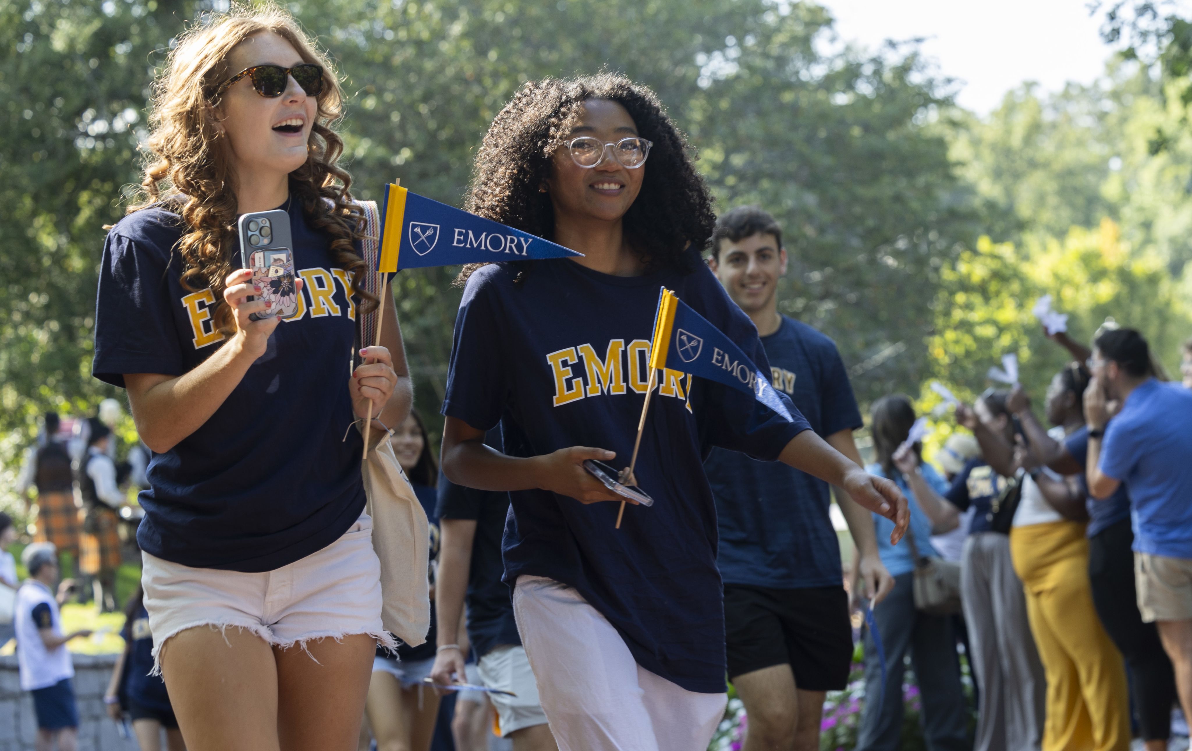 Students in Emory shirst wave Emory penants and take video