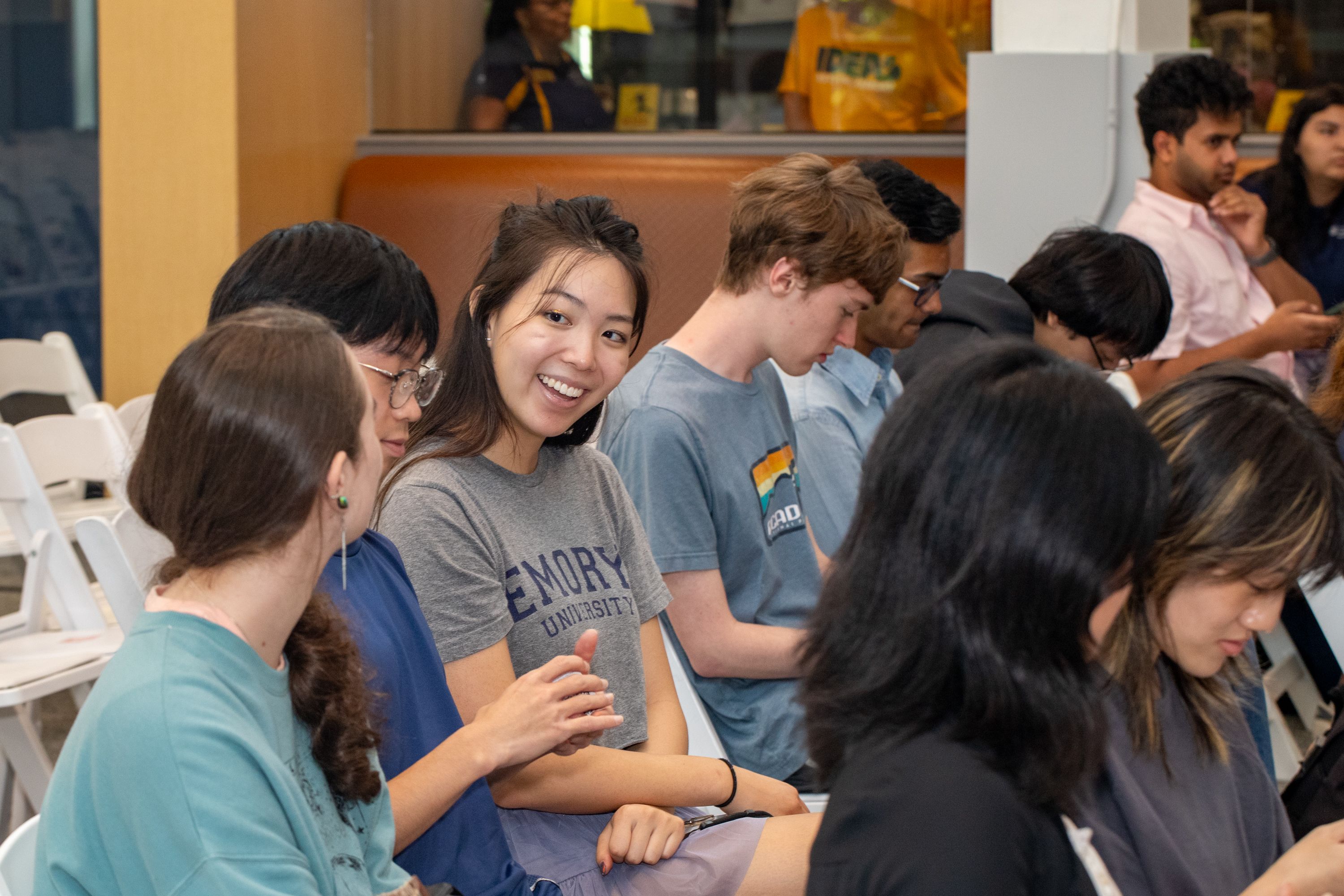 student smiling in audience for presentation
