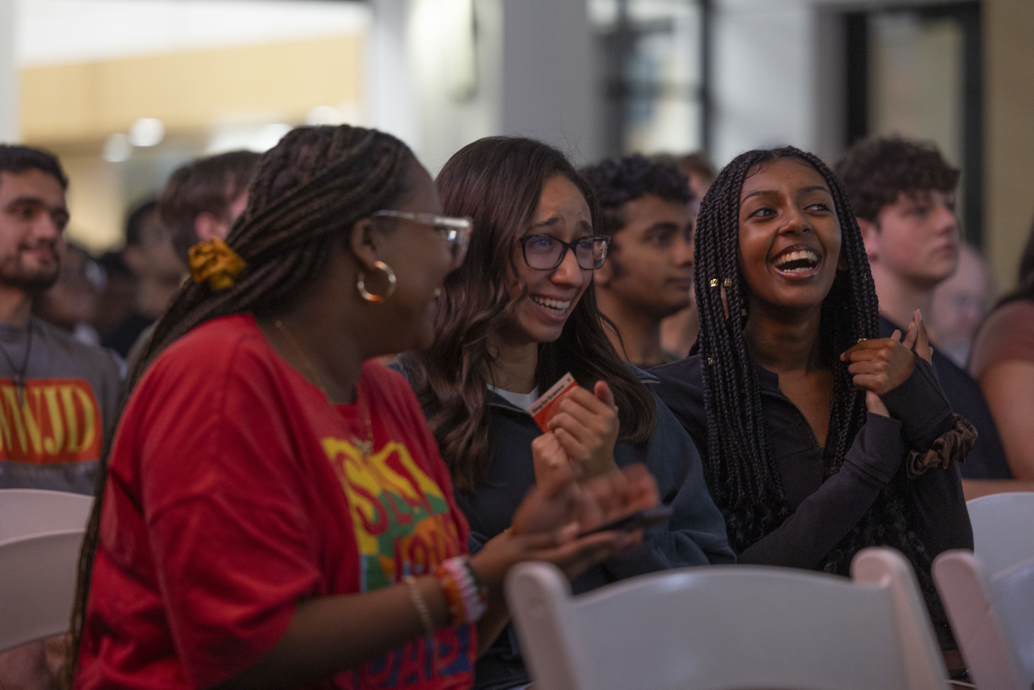 three women in audience laughing
