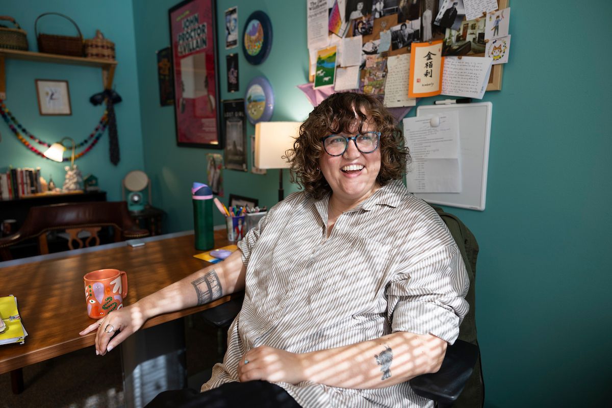 Playwright Kimberly Belflower sits, smiling, at her desk at Emory University.