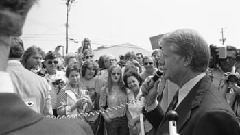 Jimmy Carter holds a small microphone as he speaks to a crowd