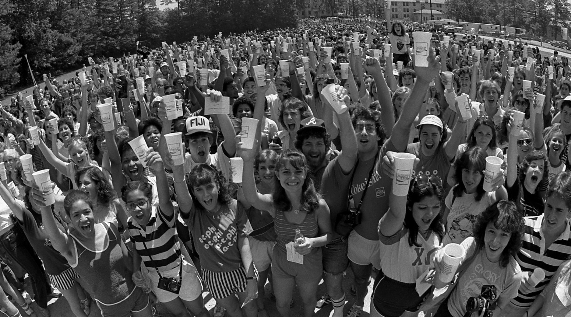 Photo of Emory students gathered to give the first Coke Toast in June 1982.