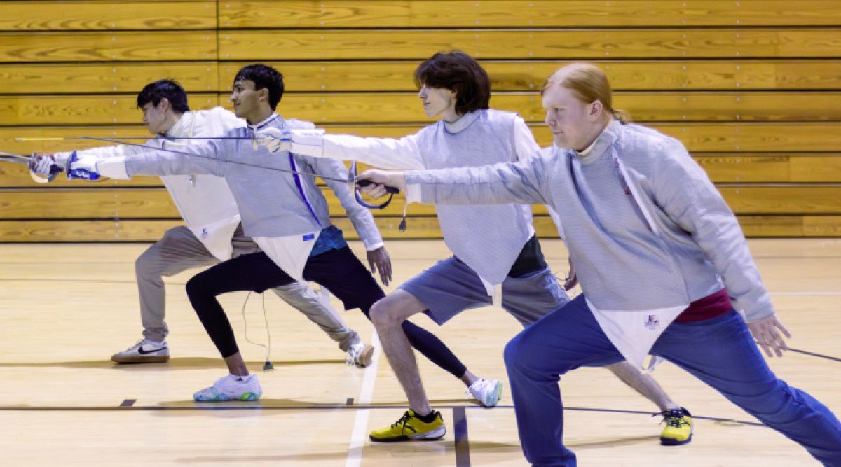 Photo of four student fencers practicing their lunges.