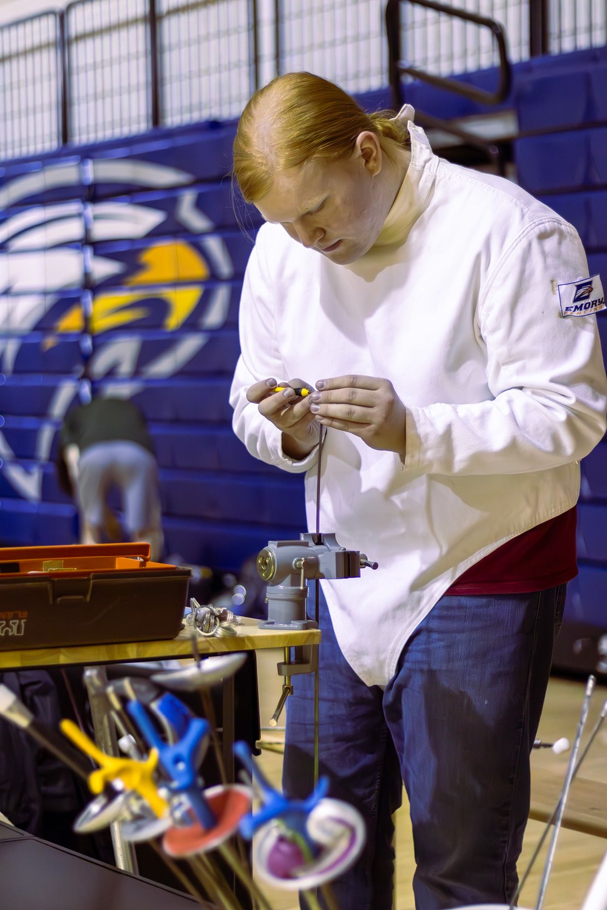Photo of student Miles Straw fixing fencing gear.