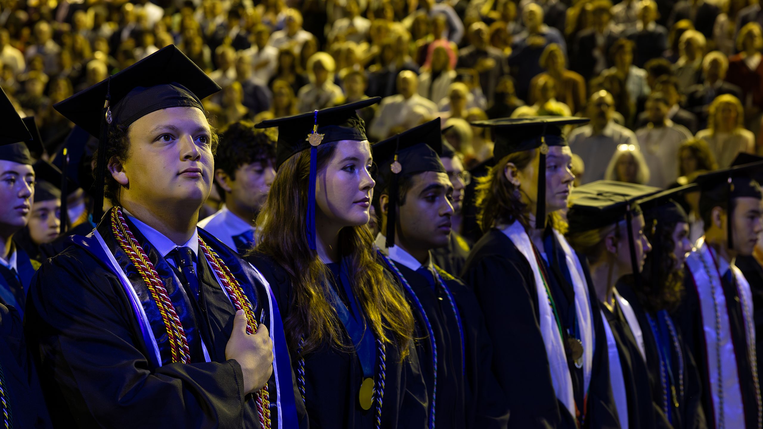 Students rise for the Pledge of Allegiance