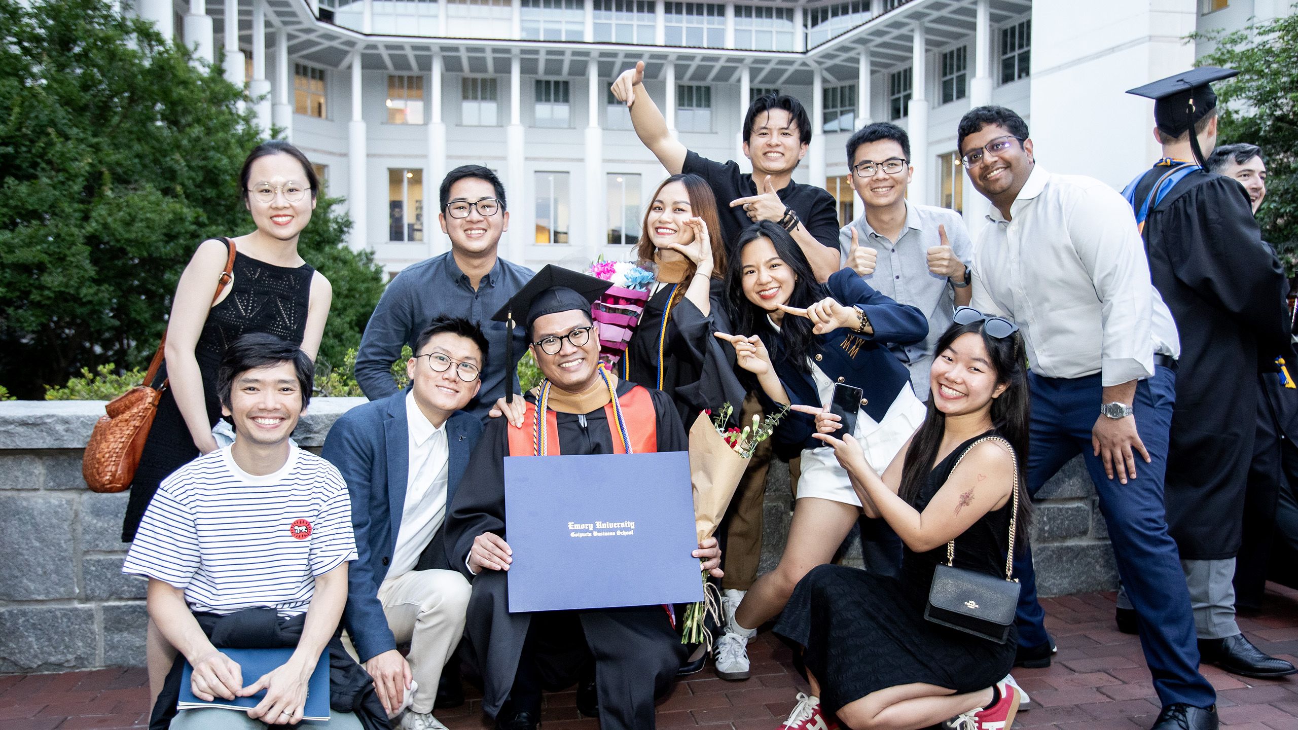 Family and friends pose with a graduate and his diploma