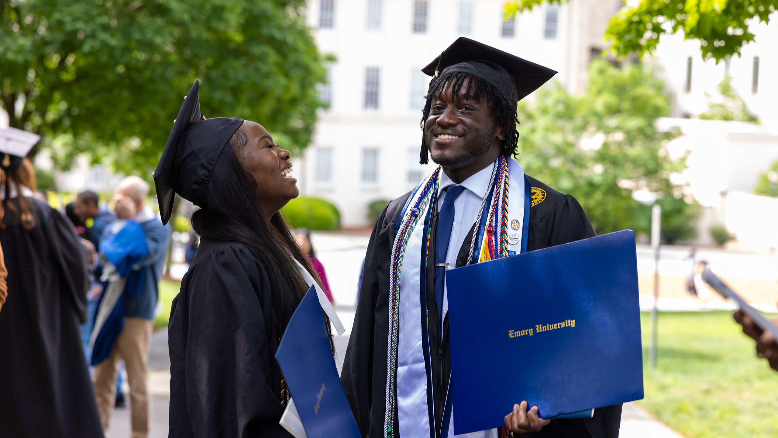 Grads laugh while standing outside