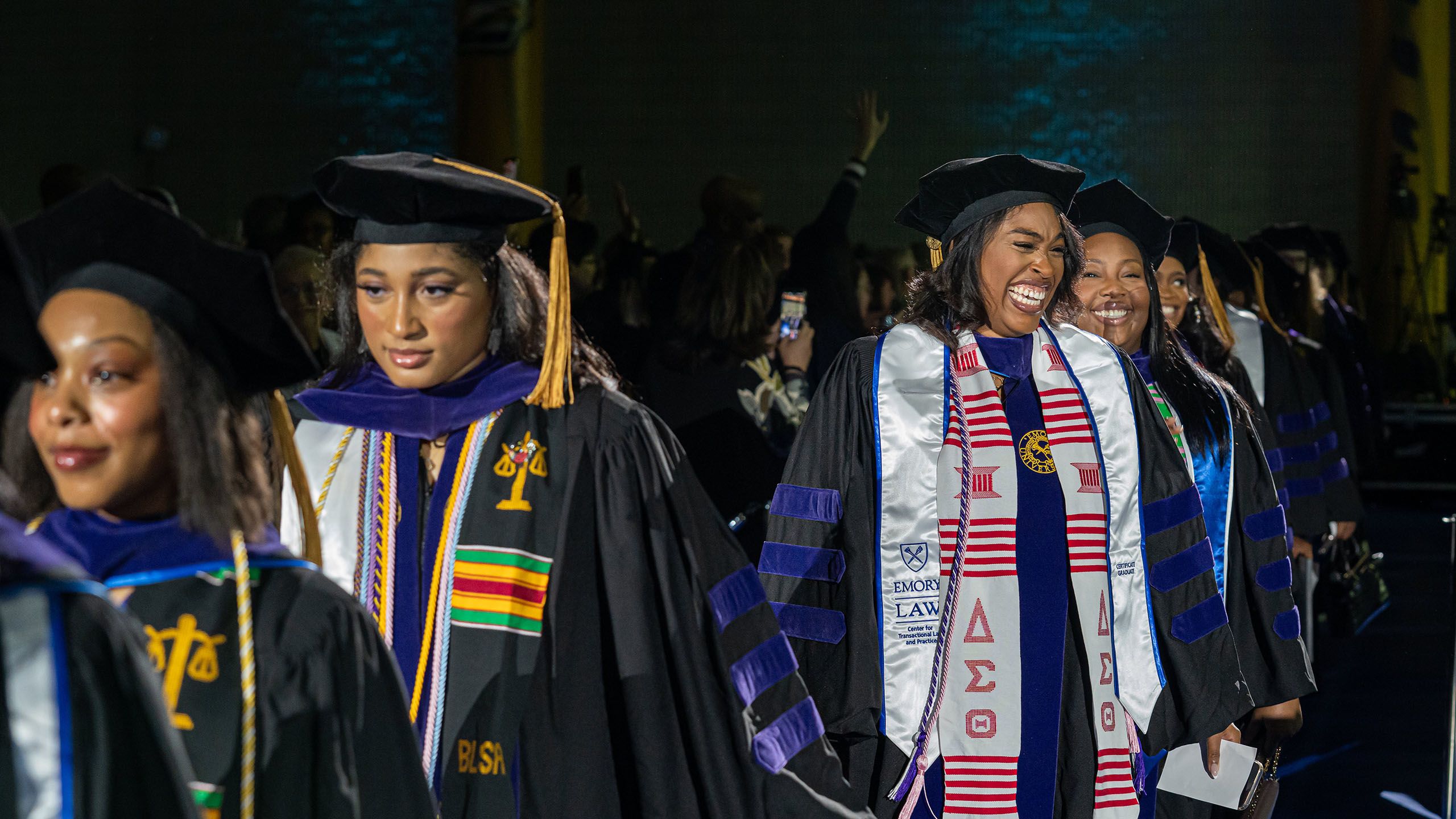 A row of smiling graduates in caps and gowns