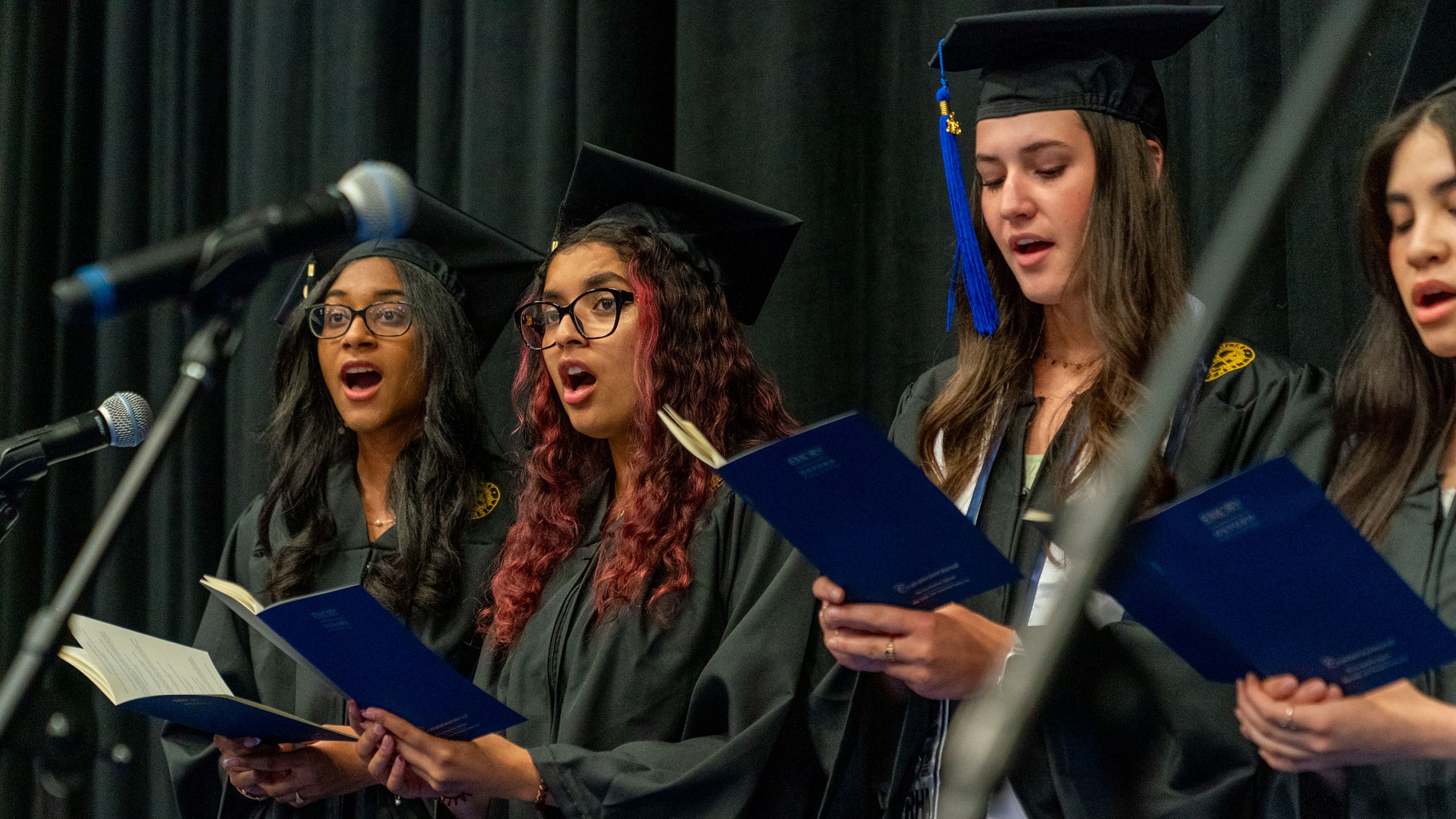 Students in caps and gowns sing