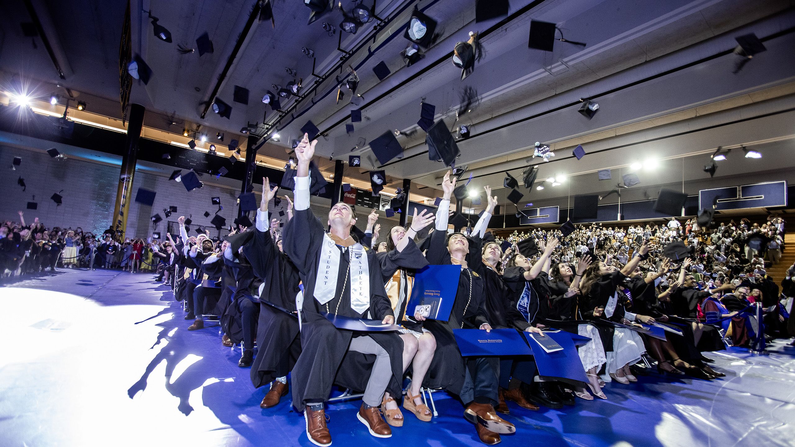 Graduates toss their caps in the air