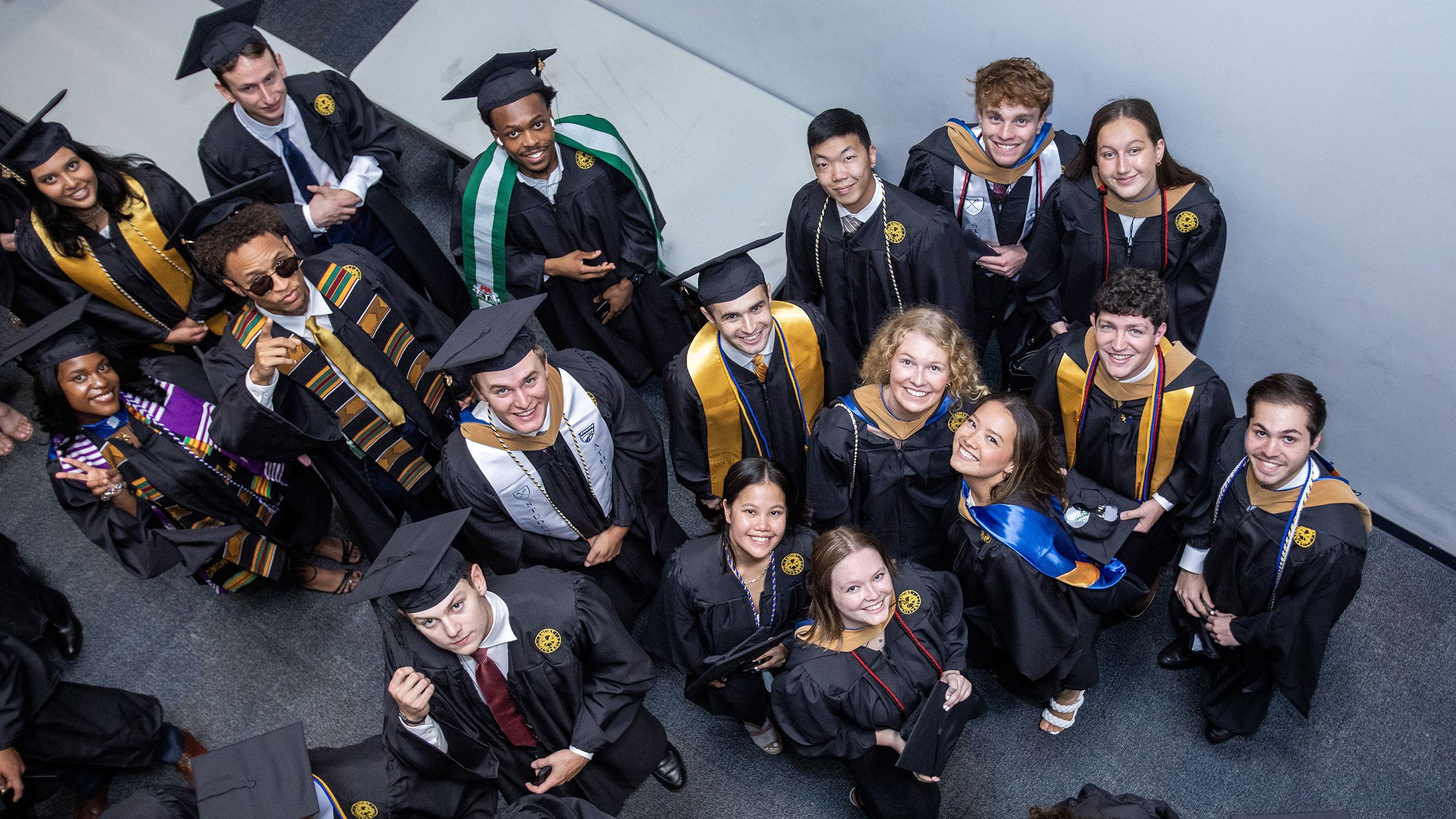 Graduates look up and smile for a photo taken from above