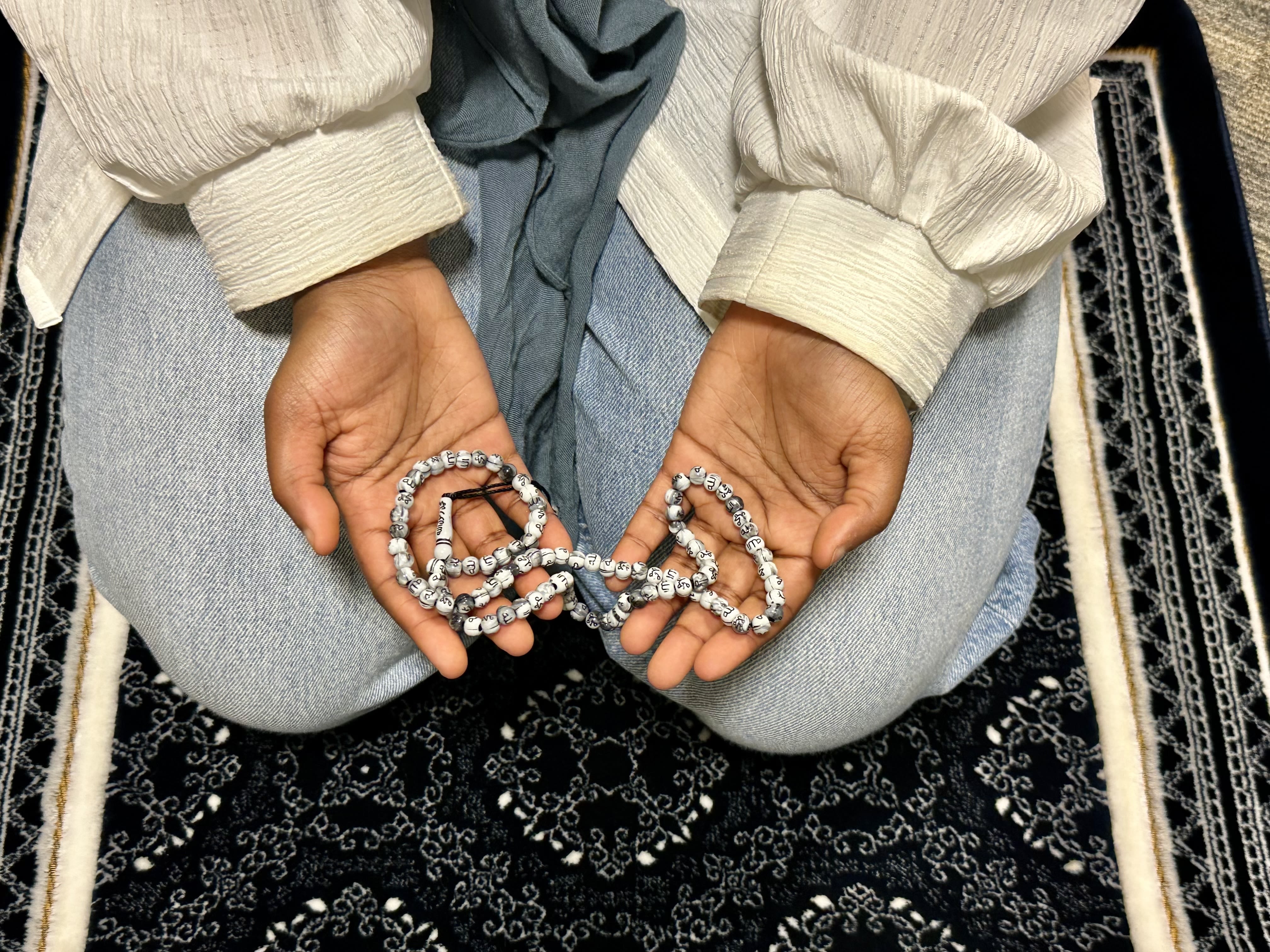 Hands holding a string of prayer beads