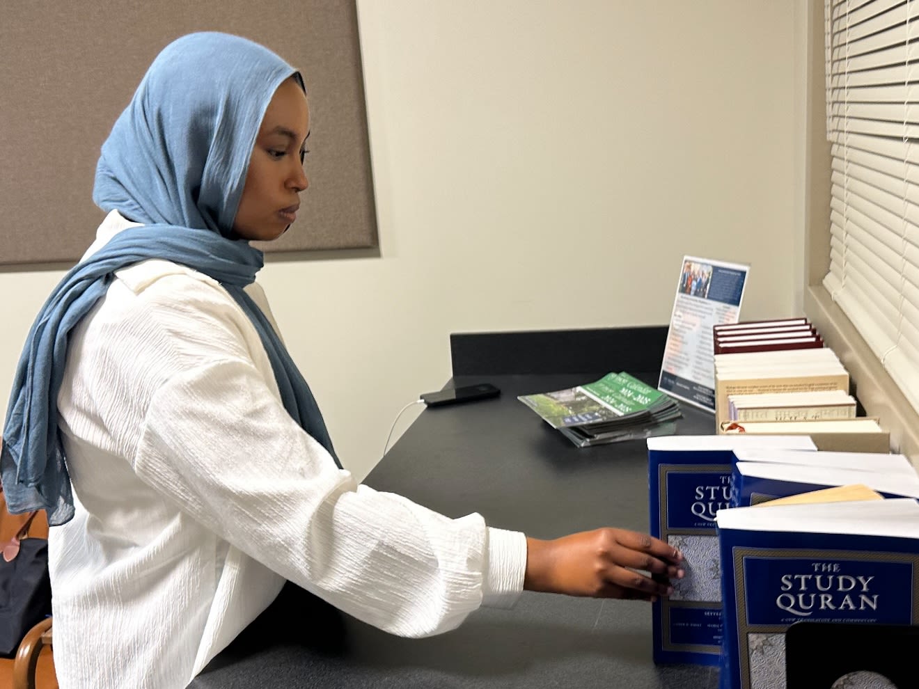 Sahra Omar putting book on shelf