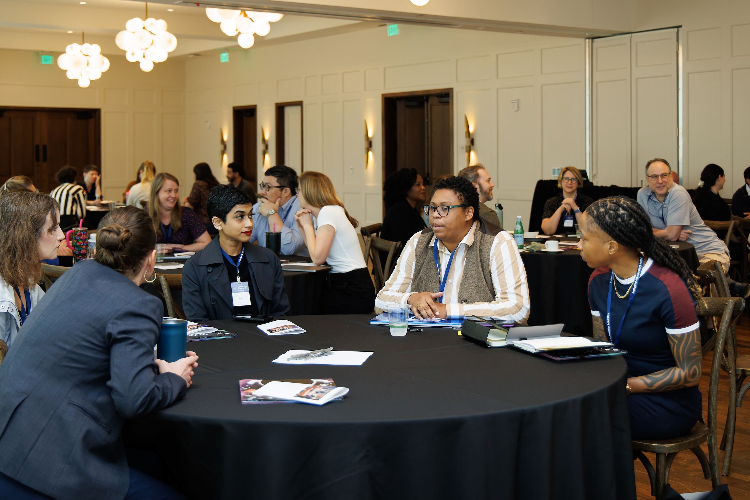 Academy participants seated at table in discussion