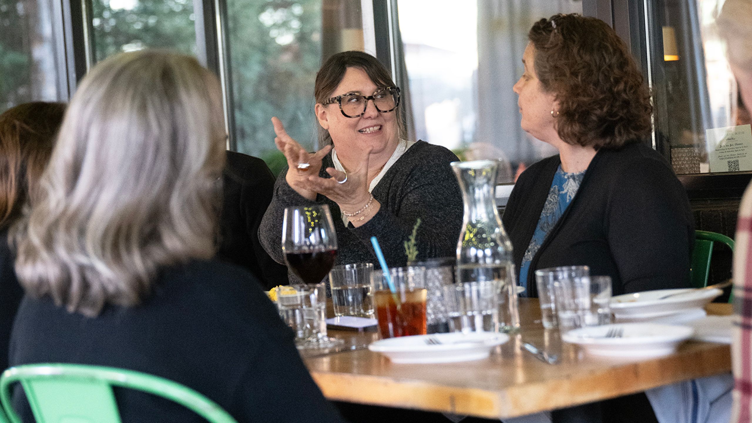 Three women sitting at Emory Health Digest's Dinner with a Doctor event at a table, talking. 