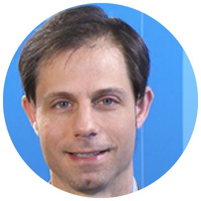 Head shot of man smiling with blue background