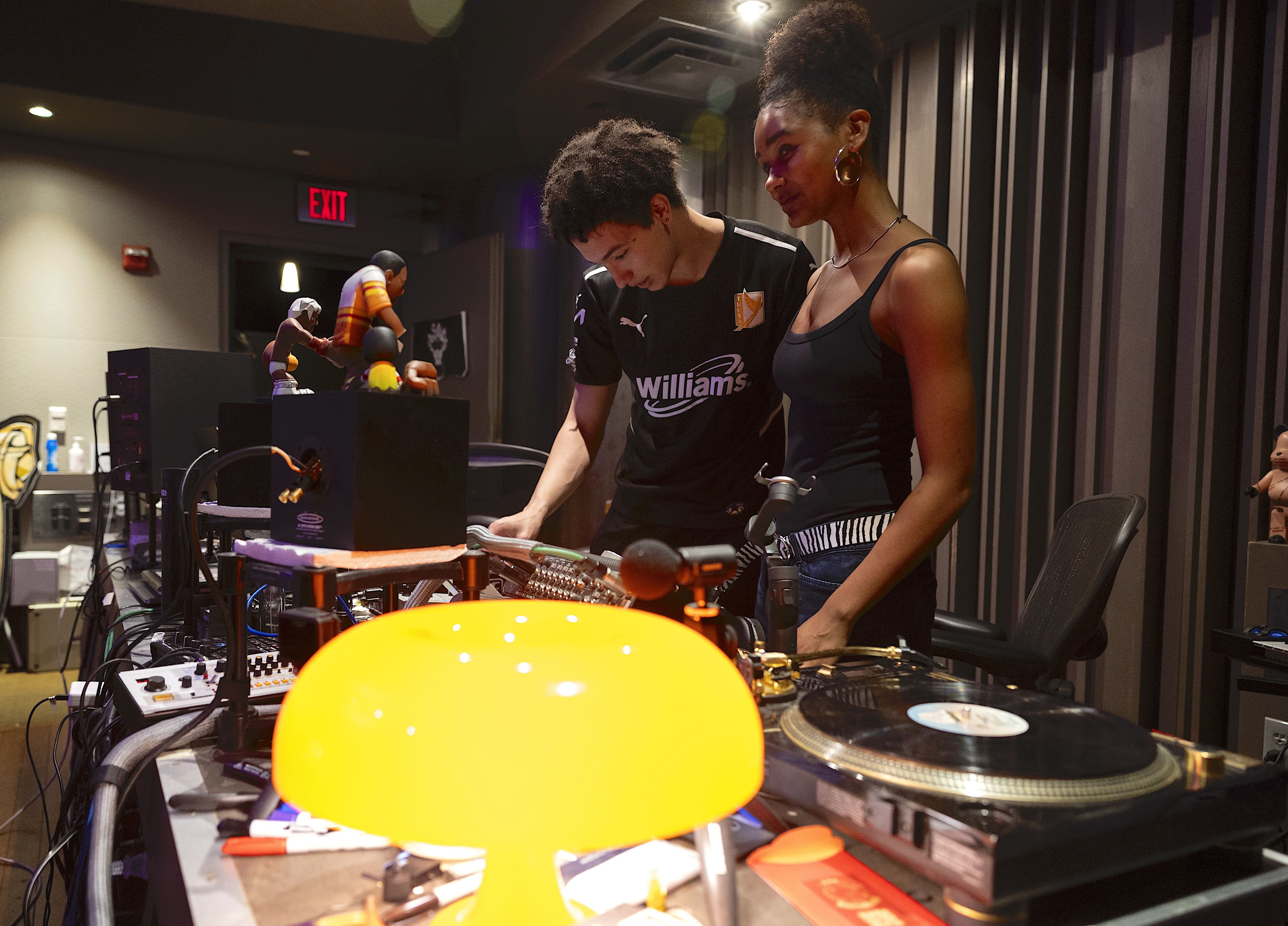 Two Emory students interns look at the mixing board in studio