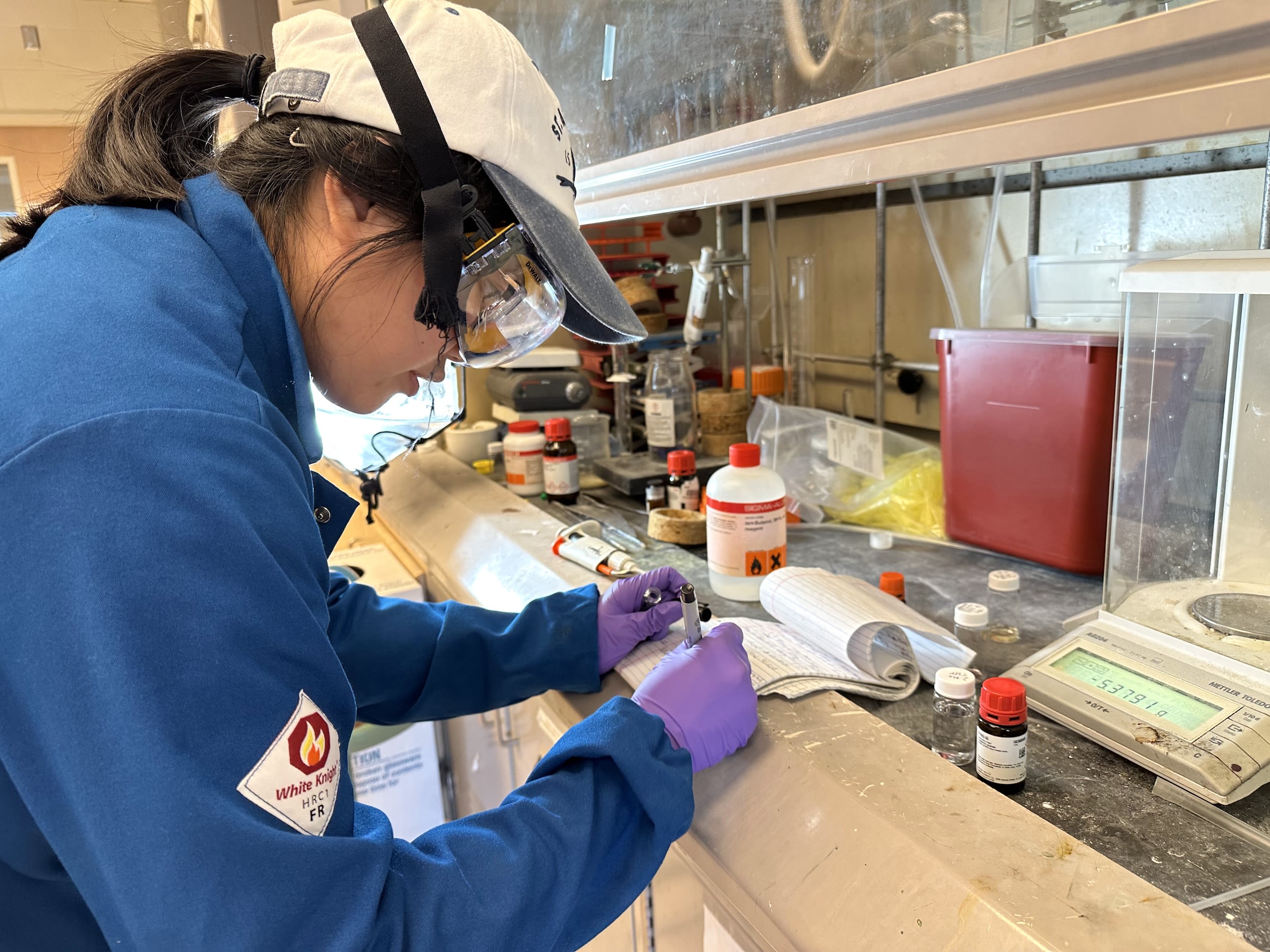 San Pham shown taking notes in the lab