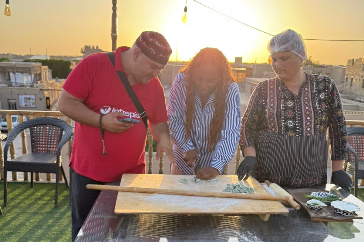 Student receiving instruction on rolling pasta at sunset