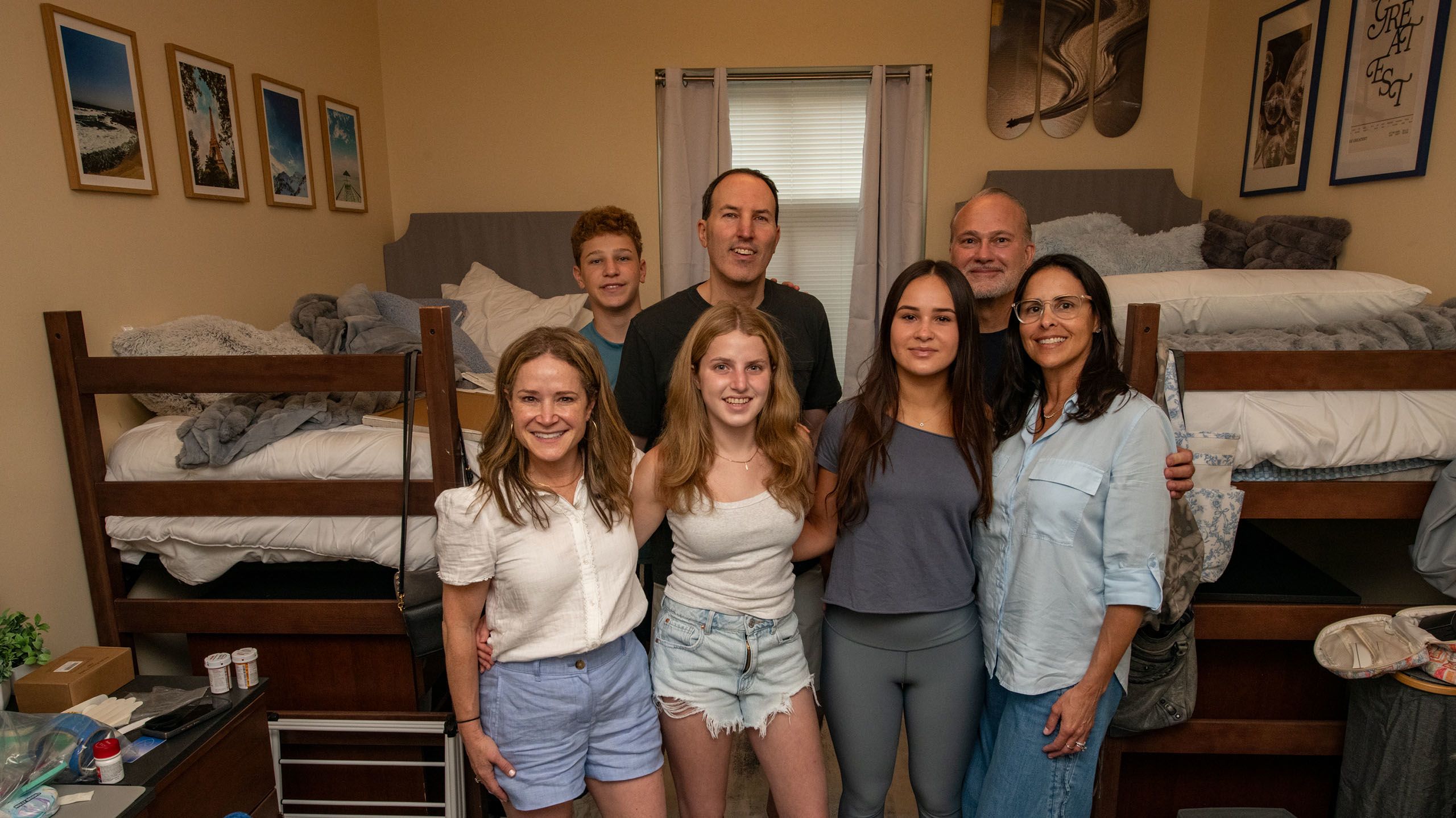 Two families standing together and smiling in their daughters' new room