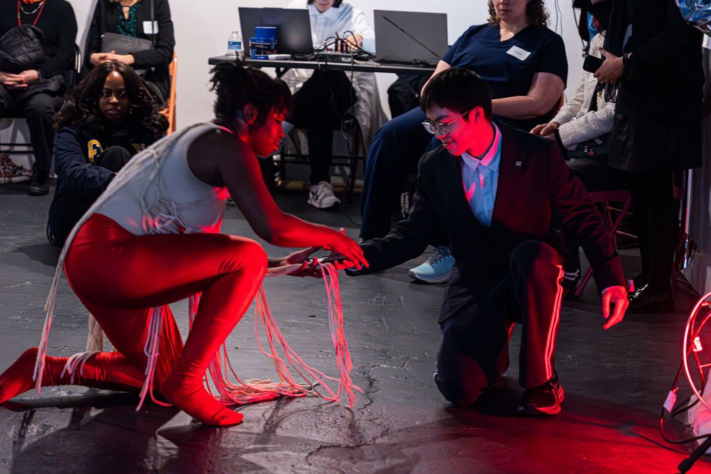 Dancer and music student looking at mobile device during a performance. Photo by John Stephens.
