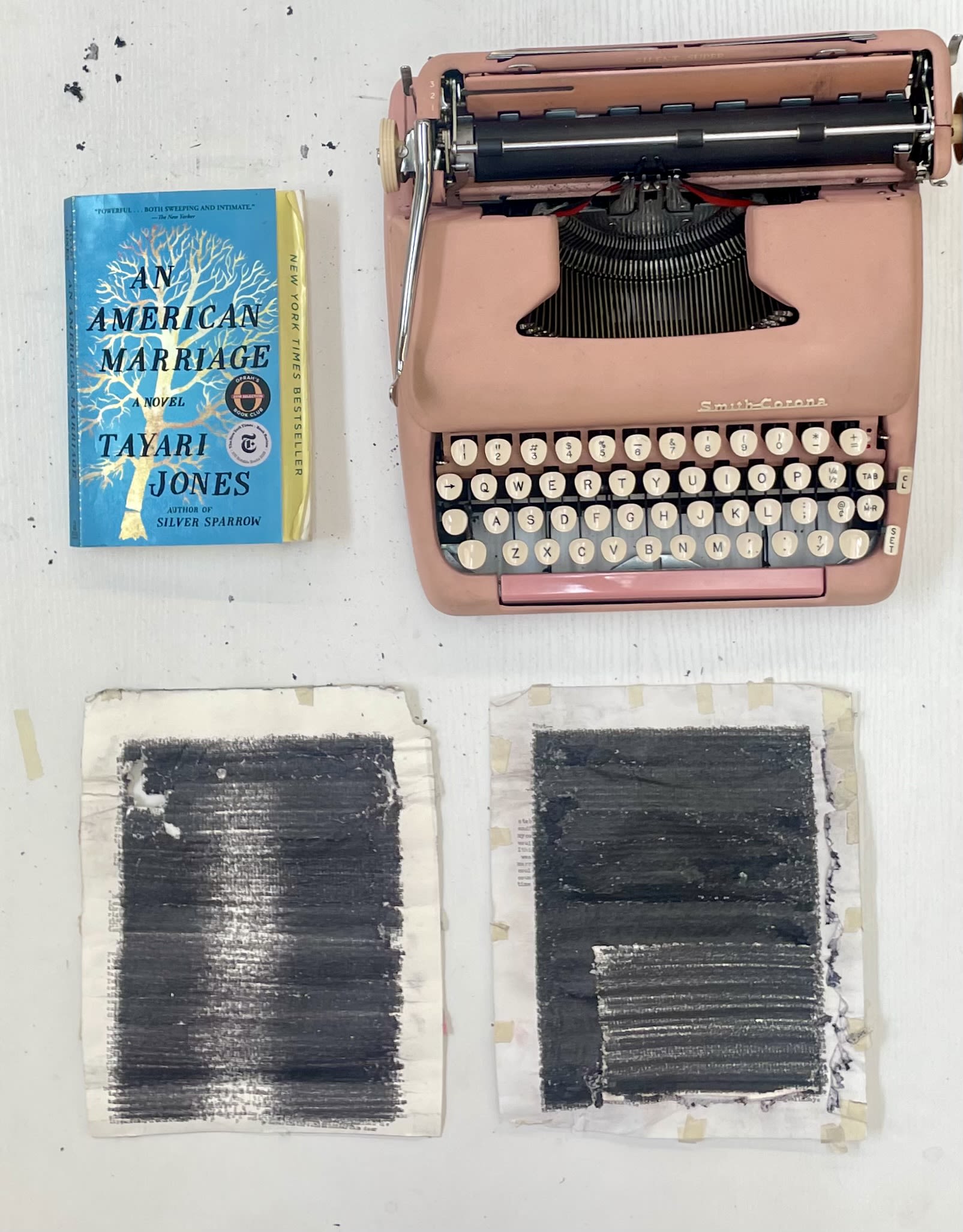 The novel "An American Marriage," a light pink typewriter, and two typewritten pages