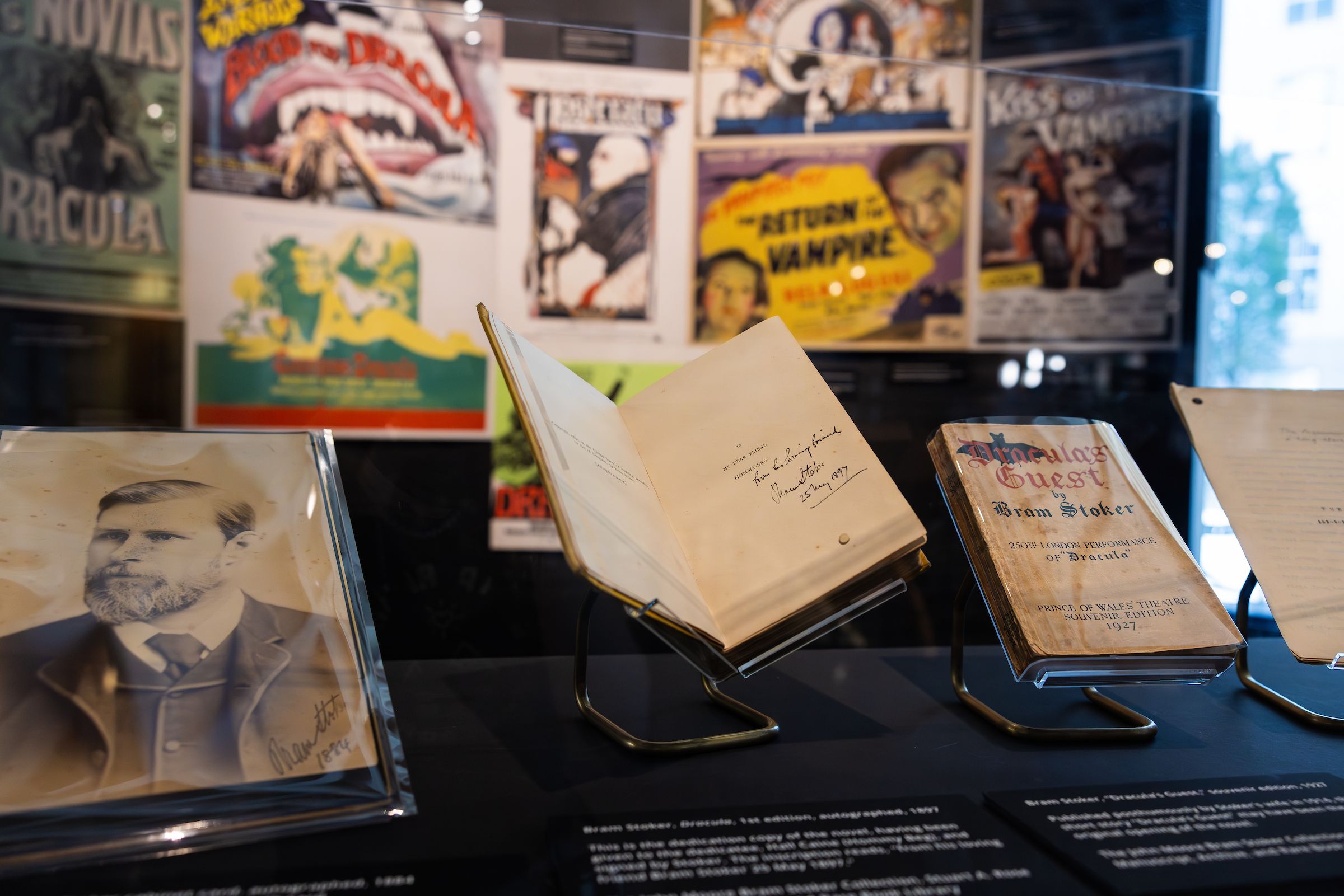 In the foreground: a photograph of Bram Stoker next to several of his books. In the background: movie posters featuring a variety of "Dracula" films.