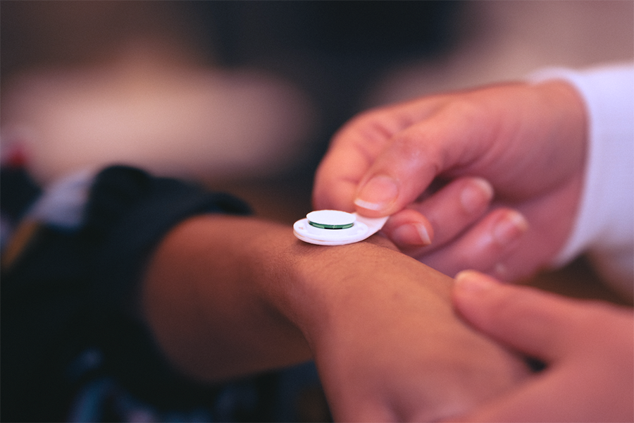 Someone placing a micro needle patch on a hand