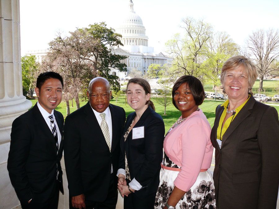 Group photo of three students, Rep. Lewis and Dean McCauley with the U.S. Capitol in the distant background