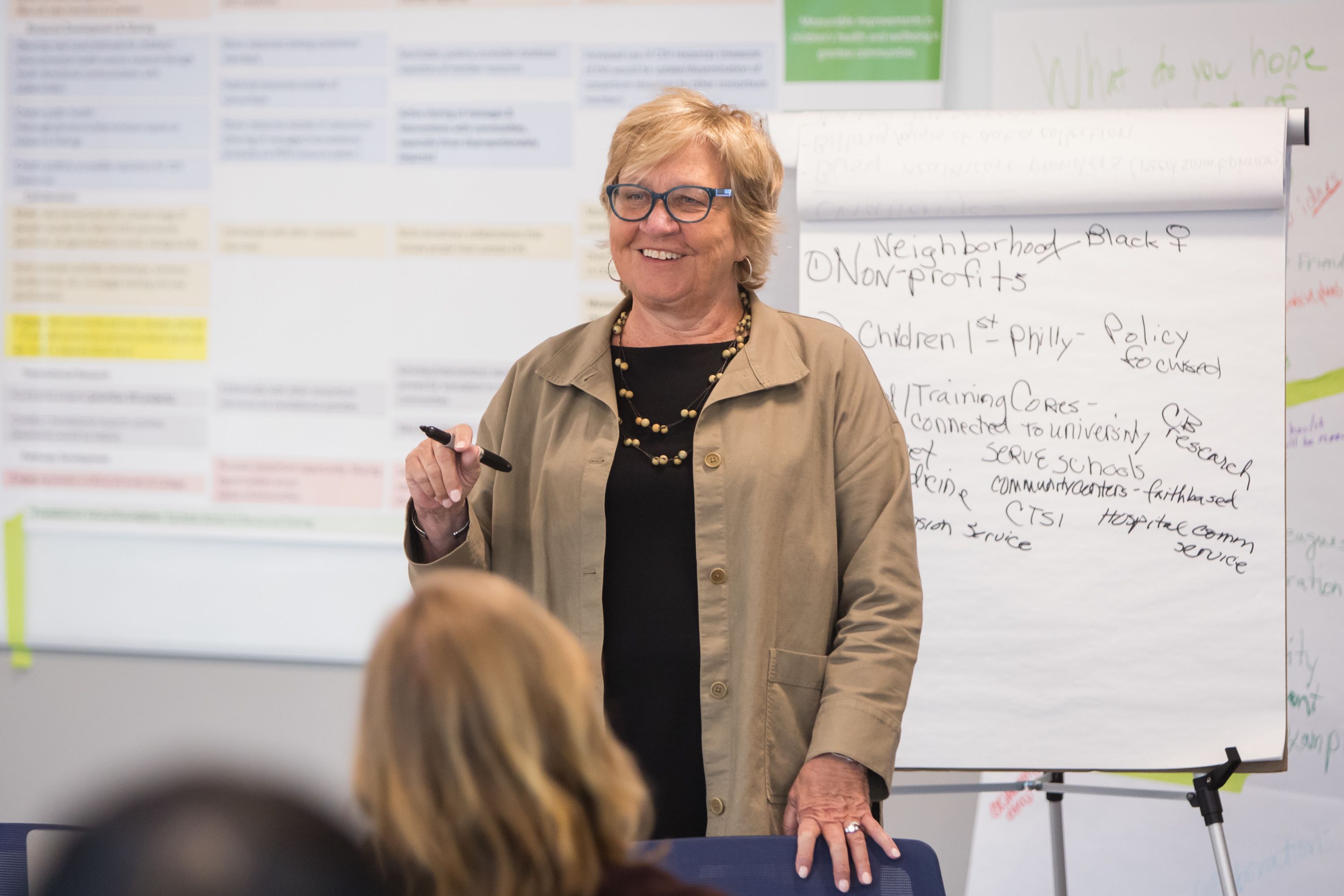 Action shot of Dean McCauley standing at the front of a classroom in front of a large paper pad with a marker