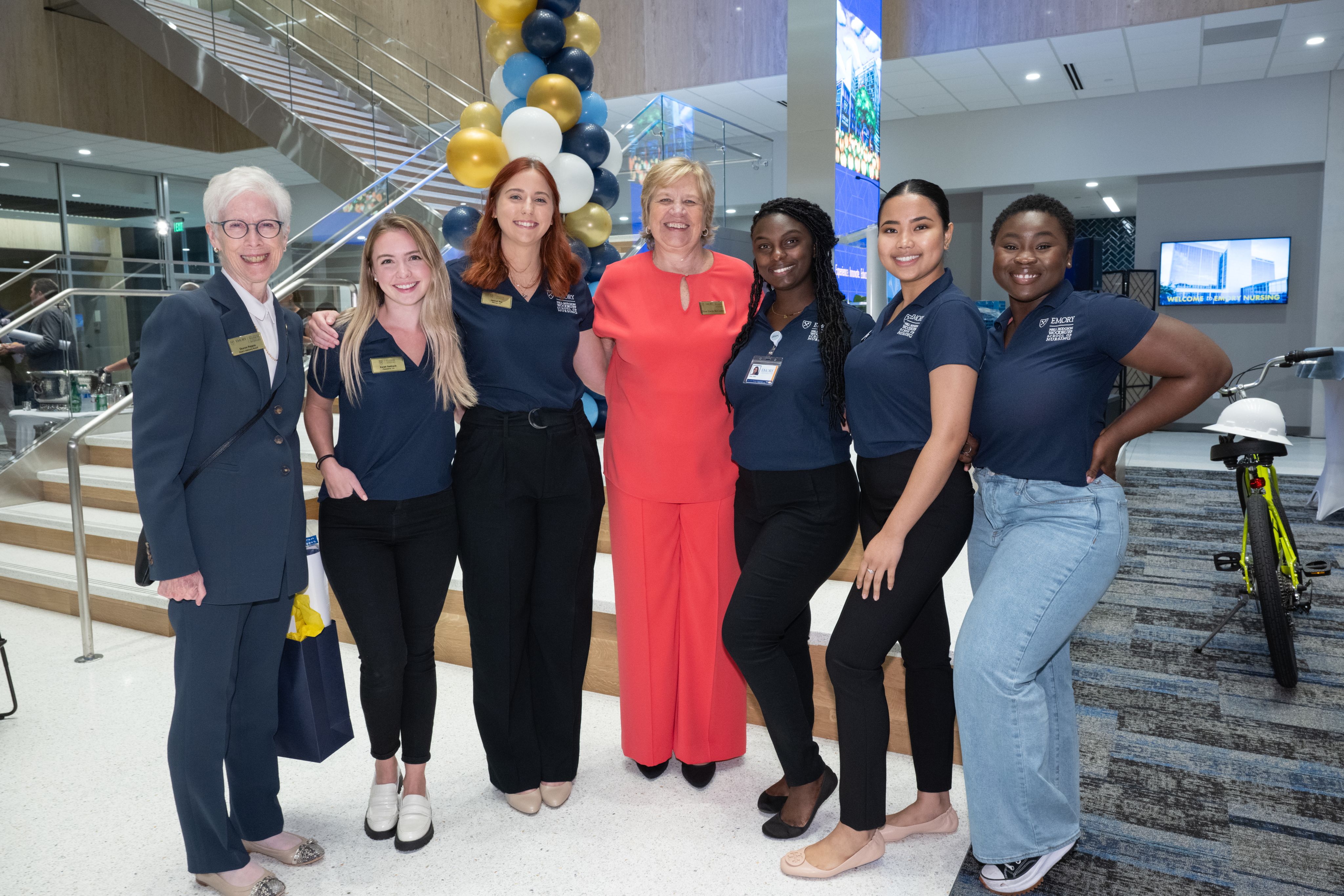 A group photo in the lobby of the center with balloons in the background.