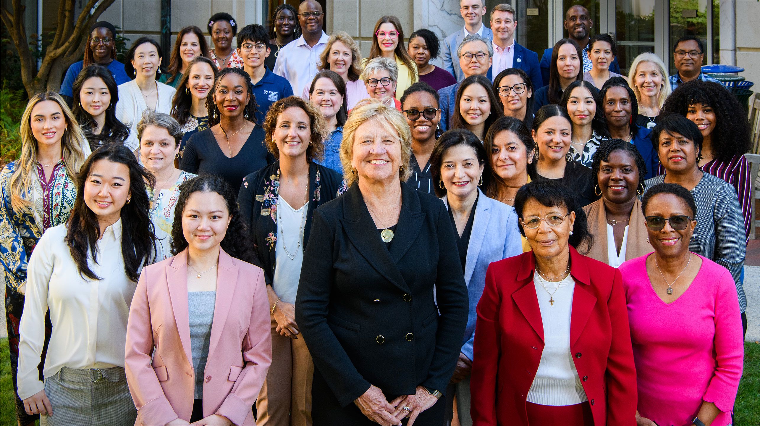 Portrait of Dean Linda McCauley with approximately 50 community members outside the main building of the Nell Hodgson Woodruff School of Nursing. They are all smiling and looking directly at the camera.