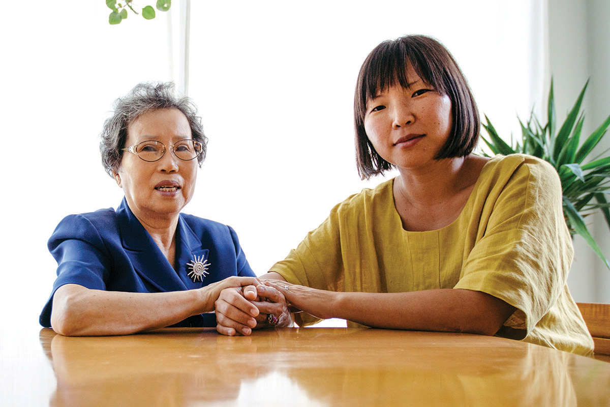 Elderly woman seated next to her daughter