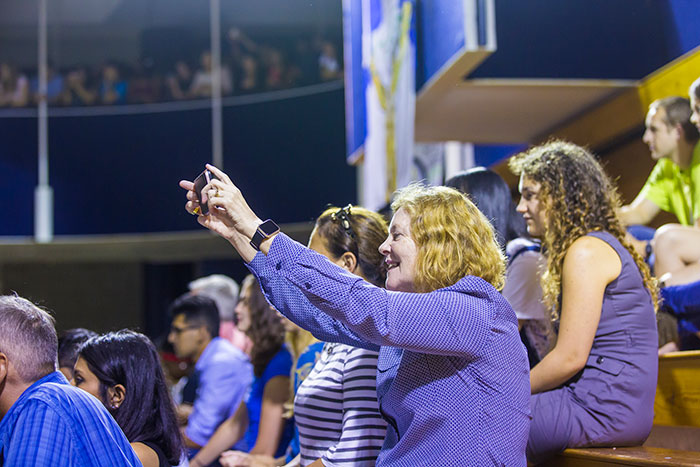President Claire E. Sterk takes a video from the crowd.
