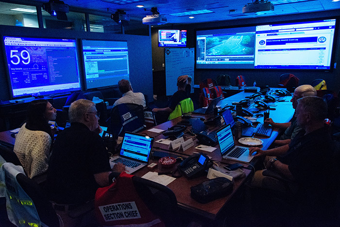 The Office of Critical Event Preparedness and Response monitors Hurricane Irma on a large screen.