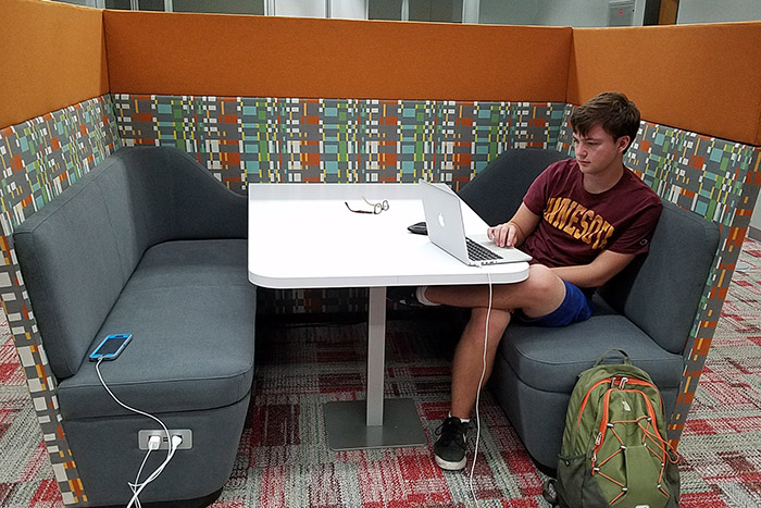 Donald Grasse, a graduate student at Emory, sits in a the new study booth with his laptop.