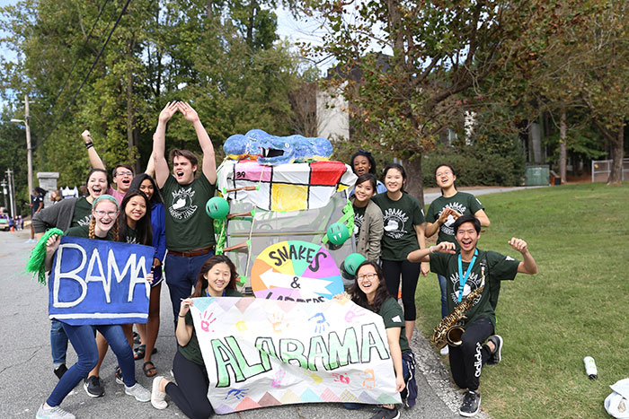 Emory students pose with hand-decorated signs at the 2017 homecoming parade.