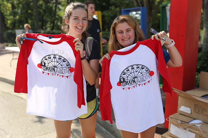 Two female students pose with their "Run AMUC" baseball t-shirts.