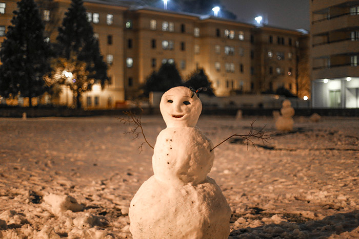 An intricately sculpted snowperson stands tall on Friday evening after a few inches of snow have fallen on campus.