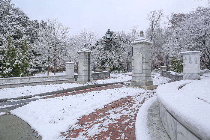 The iconic Emory gate is still adorned with a few inches of snow Saturday morning.