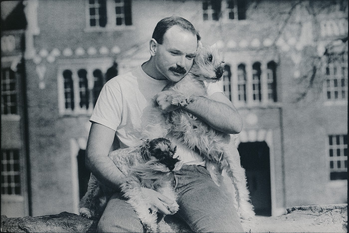 Photo from the exhibit of a man named Tom, pictured with his two dogs.