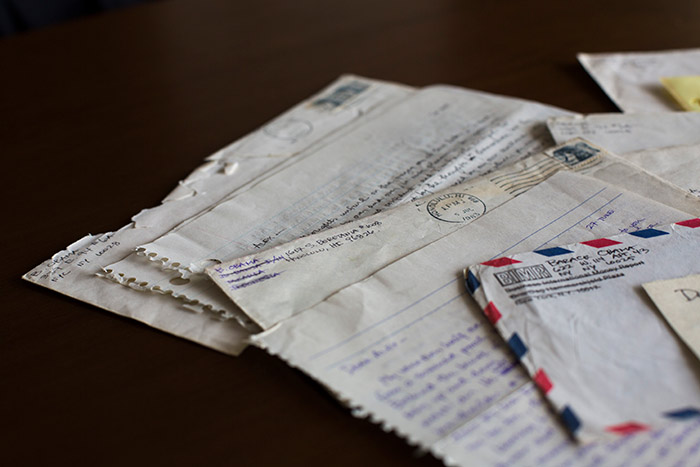 Several other letters and their envelopes sit, fanned out on a table.